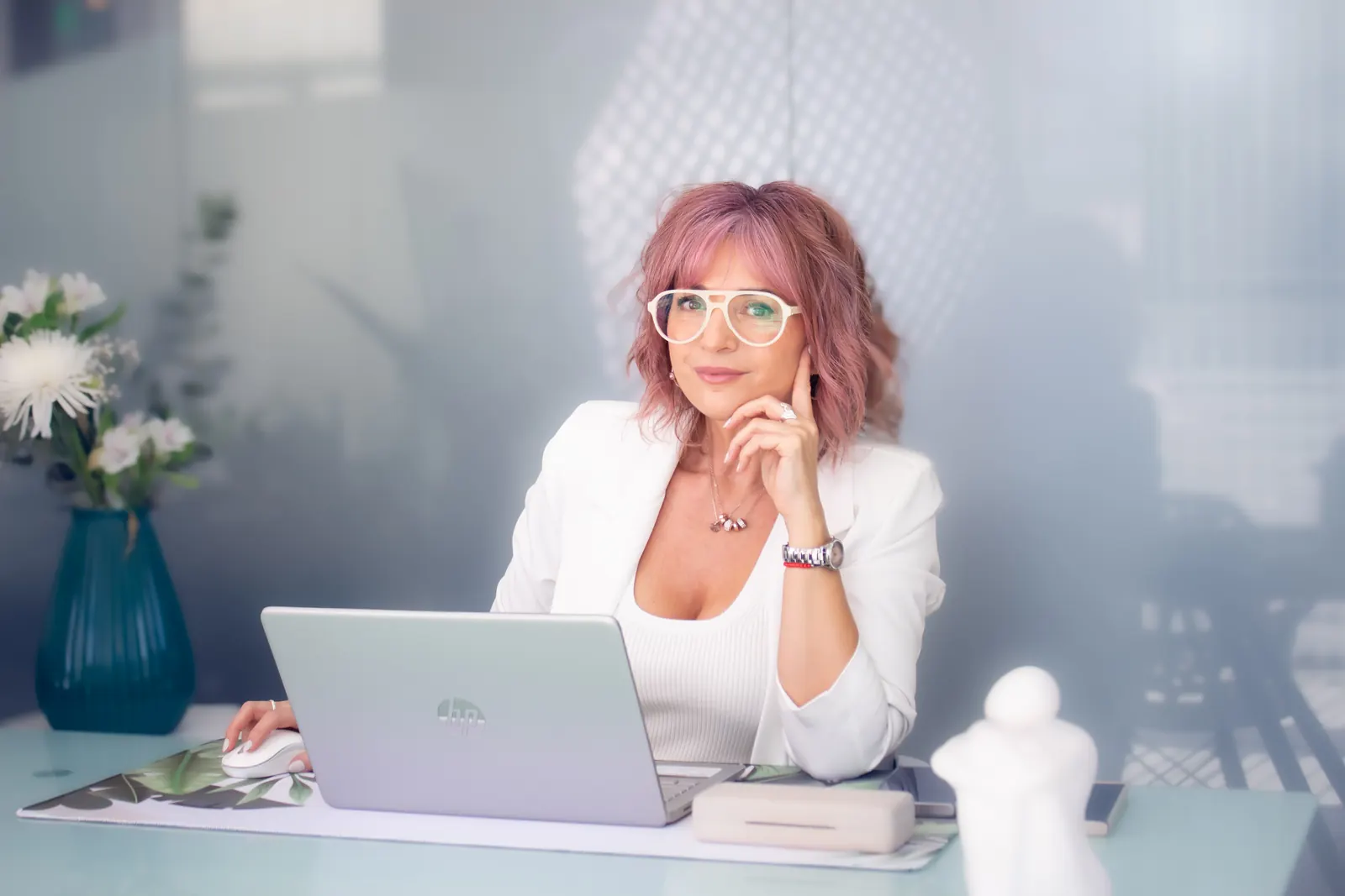 Andrea Guevea, asesora de imagen, en su escritorio con anteojos y blazer blanco