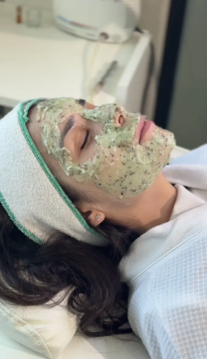 Clienta relajada con máscara facial de algas durante un facial premium