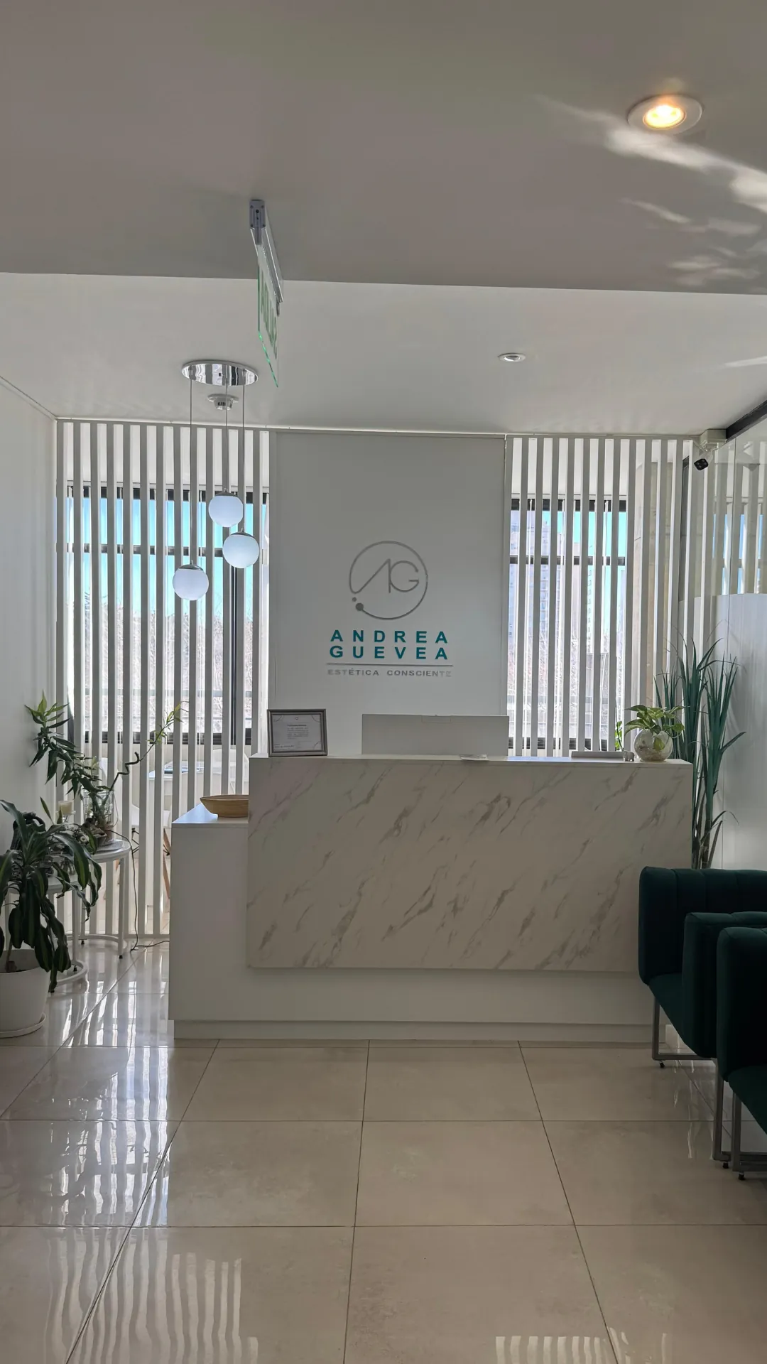 Recepción del centro con el logo Andrea Guevea detrás del mostrador